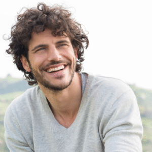 young white man smiling with mountains in the background